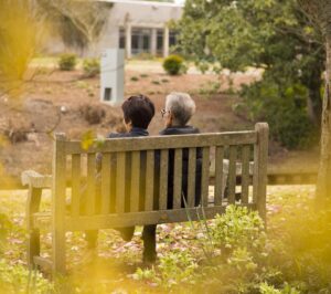 pár v seniorském věku sedí na lavičce v parku