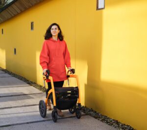 žena před sebou tlačí chodítko