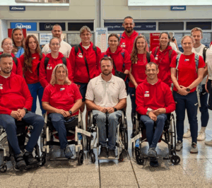 Skupinová fotografie první části výpravy paraatletů focená v hale letiště Praha.